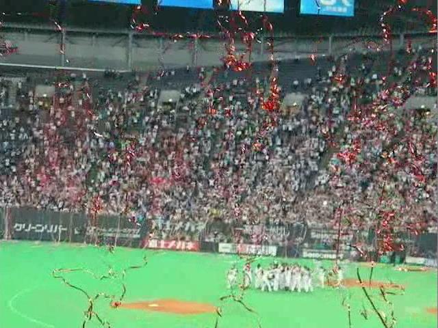優勝を決めて喜ぶ日ハムナインと舞い落ちる勝利のテープ