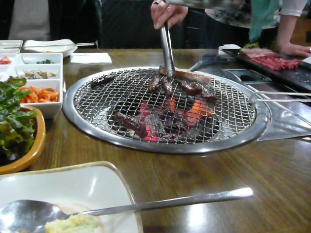 店の人が肉を焼く風景
